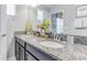 Bathroom with double sinks and granite countertop, featuring a framed mirror and modern fixtures at 1628 Moon Valley Dr, Davenport, FL 33896