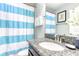 Bathroom featuring a granite countertop, white sink, and blue and white striped shower curtain at 1628 Moon Valley Dr, Davenport, FL 33896
