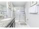 Bright bathroom featuring a glass-enclosed shower, white marble tile, and granite countertop at 1628 Moon Valley Dr, Davenport, FL 33896