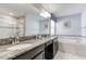 Bathroom features double vanity with granite countertop, soaking tub, tiled floors, and glass shower at 1628 Moon Valley Dr, Davenport, FL 33896