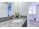 Bathroom with granite countertops, a white sink, and a view of a carpeted hallway at 1628 Moon Valley Dr, Davenport, FL 33896