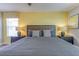 Bright bedroom features a bed with decorative pillows flanked by bedside tables with lamps at 1628 Moon Valley Dr, Davenport, FL 33896