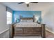 Comfortable bedroom featuring a ceiling fan and a large bed with blue accent wall and carpet flooring at 1628 Moon Valley Dr, Davenport, FL 33896