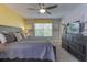 Bedroom featuring large bed, window with yellow valance, dresser with TV, and modern decor at 1628 Moon Valley Dr, Davenport, FL 33896