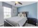 Bedroom with a queen bed, blue accent wall, and ceiling fan at 1628 Moon Valley Dr, Davenport, FL 33896