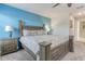 Comfortable bedroom with ceiling fan, large bed, side tables, blue accent wall, and ensuite bathroom access at 1628 Moon Valley Dr, Davenport, FL 33896