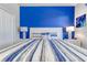 Cozy bedroom with a blue accent wall, white furniture, and soft, striped bedding at 1628 Moon Valley Dr, Davenport, FL 33896