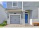 Charming two-story home with a blue door, a gray garage door, and a brick driveway at 1628 Moon Valley Dr, Davenport, FL 33896
