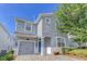 Charming two-story home with a blue door, a gray garage door, and landscaped front yard at 1628 Moon Valley Dr, Davenport, FL 33896