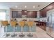 Modern kitchen with stainless steel appliances, brown cabinets, island with seating, and dining area at 1628 Moon Valley Dr, Davenport, FL 33896