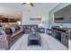 Spacious living room with open layout, leather sectional, and view of the kitchen at 1628 Moon Valley Dr, Davenport, FL 33896
