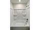 Bathroom with clean white tub and shower combo with built-in shelving for storage of bathing products at 1721 Teagan Ln, Winter Haven, FL 33884