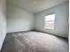 This is a bedroom with gray carpeting, white walls and a window providing lots of natural light at 1721 Teagan Ln, Winter Haven, FL 33884