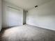 This is a bedroom with gray carpeting, white walls, a closet, and a door leading to other parts of the home at 1721 Teagan Ln, Winter Haven, FL 33884