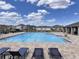 A sparkling clean community pool with lounge chairs, tables, and neighborhood homes in the background at 1721 Teagan Ln, Winter Haven, FL 33884