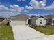 Inviting single-story home with a well-maintained lawn and an attached two-car garage at 1721 Teagan Ln, Winter Haven, FL 33884