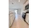 A modern kitchen with stainless steel appliances, ample cabinet space, and an adjacent living area at 1721 Teagan Ln, Winter Haven, FL 33884