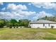 Expansive backyard with lush lawn, some palm trees, and the home's back facade in the distance at 19261 Quarterly Pkwy, Orlando, FL 32833
