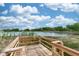 Wooden deck with view of lush foliage and serene lake under a partly cloudy sky at 19261 Quarterly Pkwy, Orlando, FL 32833