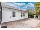 View of the backyard brick patio and white exterior of home against a bright sky at 19261 Quarterly Pkwy, Orlando, FL 32833