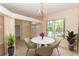 Elegant dining room with a chandelier, modern chairs, a round table, and a large window offering scenic views at 19261 Quarterly Pkwy, Orlando, FL 32833