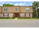 Charming two-story townhouse featuring a brick facade, red shutters, and a well-manicured front lawn at 200 St Andrews Blvd # 512, Winter Park, FL 32792