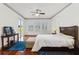 Bedroom with hardwood floors, a ceiling fan, and three bright windows looking out onto the yard at 2328 Warren Woods Dr, Orlando, FL 32835