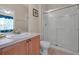 Bright bathroom features a glass-enclosed shower and a wooden vanity with ample storage space at 2355 Silver Palm Dr, Kissimmee, FL 34747