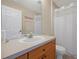 Well-lit bathroom with a single sink vanity and shower with white curtain at 2355 Silver Palm Dr, Kissimmee, FL 34747