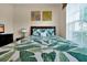 Cozy bedroom featuring vibrant leaf-patterned bedding and bright natural light from the window at 2355 Silver Palm Dr, Kissimmee, FL 34747