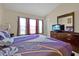 Bright bedroom features a dresser with TV, three windows and colorful bedding at 2355 Silver Palm Dr, Kissimmee, FL 34747
