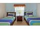 Inviting bedroom with two twin beds, beachy decor, and a sunny window view at 2355 Silver Palm Dr, Kissimmee, FL 34747