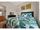 Comfortable bedroom showcases vibrant leaf-patterned bedding, tv, and an adjacent bathroom at 2355 Silver Palm Dr, Kissimmee, FL 34747