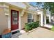 Inviting entrance to townhome with a red front door, bench, and manicured shrubs at 2355 Silver Palm Dr, Kissimmee, FL 34747