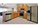 Full kitchen view with stainless steel appliances, wood cabinets, and tile flooring at 2355 Silver Palm Dr, Kissimmee, FL 34747