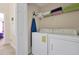 Functional laundry room with a washer, dryer, shelving, and ironing board at 2355 Silver Palm Dr, Kissimmee, FL 34747