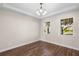 Dining room featuring hardwood floors, neutral walls, two windows, and tray ceilings with chandelier at 2383 Regency Park Dr, Deland, FL 32724