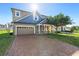 Inviting home with a brick driveway, an attached garage, and a well-maintained front yard with shade trees at 2383 Regency Park Dr, Deland, FL 32724