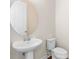 Half bathroom with pedestal sink, round mirror, and white fixtures at 2383 Regency Park Dr, Deland, FL 32724