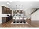 Kitchen with island featuring modern pendant lights and barstool seating and open access to the living room and stairway at 2383 Regency Park Dr, Deland, FL 32724