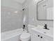 Bathroom featuring tiled shower and bath, stylish mirror, white vanity, and modern finishes at 2417 Healy Dr, Orlando, FL 32818