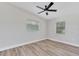 This bedroom features wood-look flooring, neutral walls, a modern ceiling fan, and two windows for natural light at 2417 Healy Dr, Orlando, FL 32818