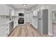 Well-lit kitchen featuring modern appliances, white cabinets, and stylish backsplash at 2417 Healy Dr, Orlando, FL 32818