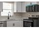 Close-up showcasing stainless appliances, white cabinetry, and quartz countertops in a modern kitchen at 2417 Healy Dr, Orlando, FL 32818