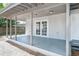The covered patio boasts gray concrete floors, white trim, and a set of double doors to the home's interior at 2417 Healy Dr, Orlando, FL 32818