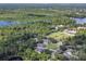 Aerial view of property near a lake, wooded area and green grass at 271 W 11Th St, Chuluota, FL 32766