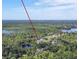 A home with lush trees, located near a lake and visible skyline under a bright, clear sky at 271 W 11Th St, Chuluota, FL 32766