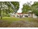Green backyard with patio, outdoor dining, and lush landscaping at 271 W 11Th St, Chuluota, FL 32766