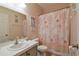 This cozy bathroom offers a shower with decorative curtain, toilet, and sink at 271 W 11Th St, Chuluota, FL 32766