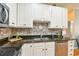 Well-lit kitchen boasts granite countertops, stainless steel appliances, and stylish backsplash at 271 W 11Th St, Chuluota, FL 32766